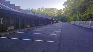 A long row of brick buildings with a row of parking spaces in front.