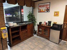 Un comedor con mostrador, cafetera, microondas y refrigerador.