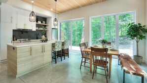 Une cuisine moderne avec des meubles en bois, un îlot central et des luminaires suspendus.