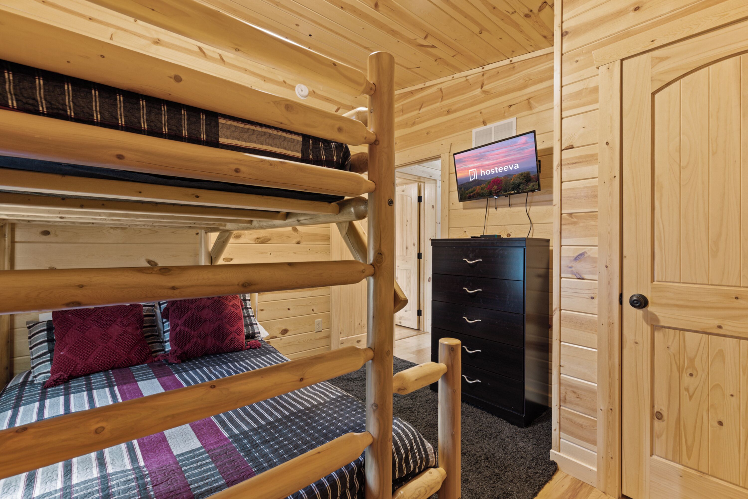A bunk bed with a television mounted on the wall above it.