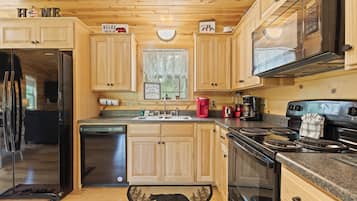 Eine moderne Küche mit Holzschränken, Edelstahlgeräten und einem Teppich mit Bärenmotiv.