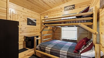 A bunk bed room with wooden walls, a window, and a sign that reads "Hibernation Station."
