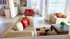 A spacious living area with a sofa set, a coffee table, and a small plant. - Delightful-3 bedroom with AC and Wifi near Oistins, St Lawrence Gap (Christ Church)