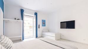 Ein modernes Schlafzimmer mit Bett, Kleiderschrank, Schreibtisch und Fernseher.