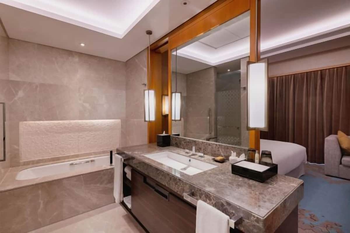 Ein modernes Badezimmer mit einer Badewanne, einem großen Spiegel und einem Waschtisch.