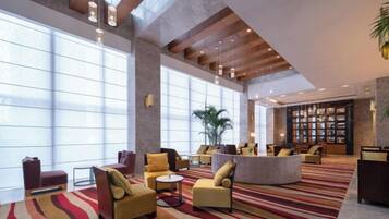 A spacious lobby with large windows, a reception desk, and seating areas.