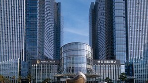 A modern hotel with a curved glass facade, surrounded by tall skyscrapers. - Yongkang World Trade International Hotel (Yongkang)
