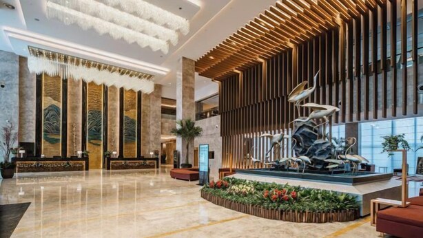 A spacious lobby with a central fountain, high ceilings with modern lighting, and a reception desk. - Yongkang World Trade International Hotel (Yongkang)