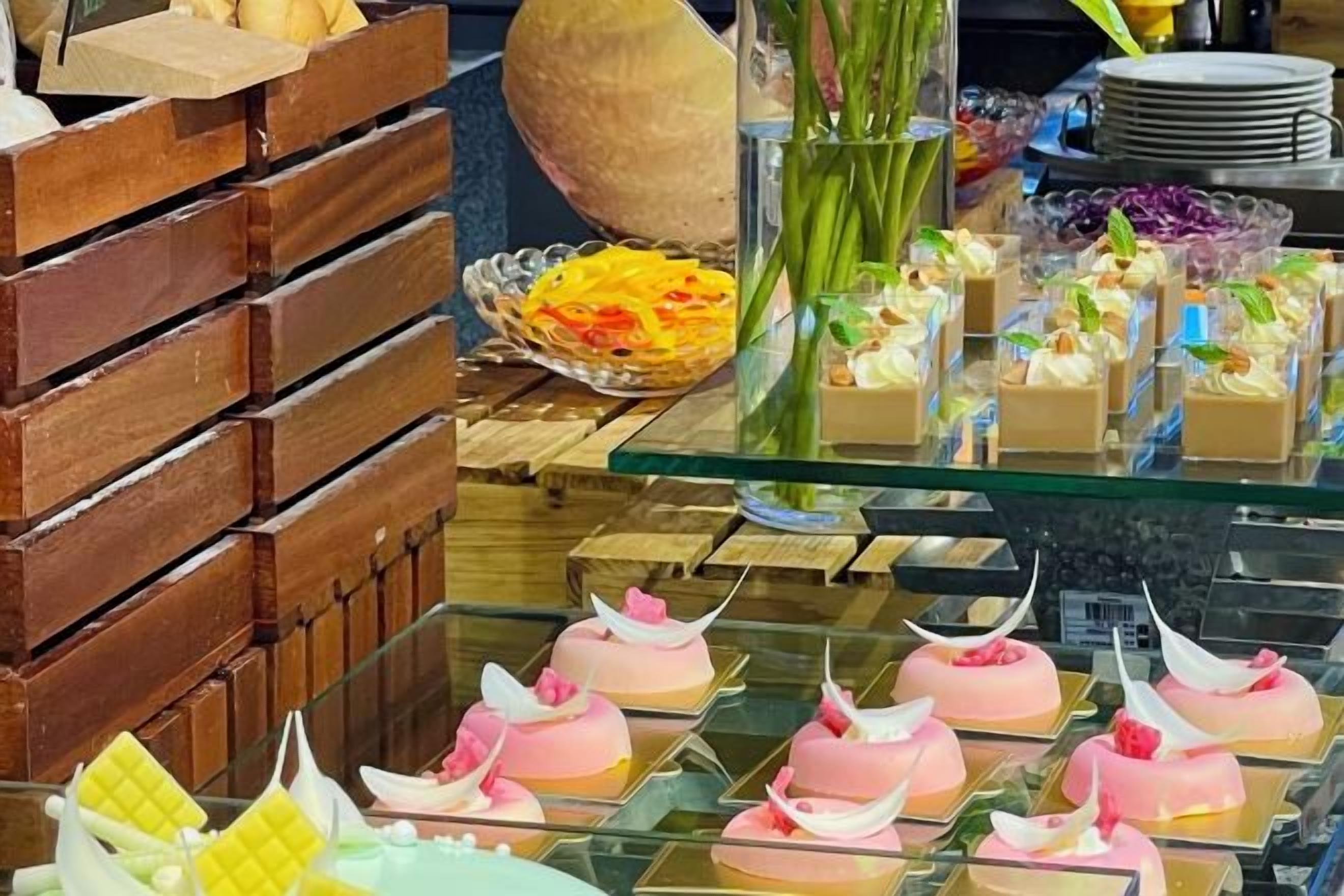 A display of various desserts and pastries on a glass counter.