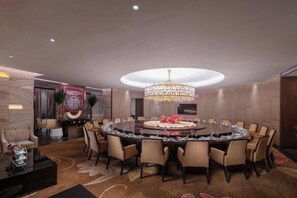 A circular dining area with a chandelier, round table, and multiple chairs. - Yongkang World Trade International Hotel (Yongkang)