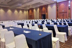 A conference room with rows of tables and chairs, a stage at the front, and a large window on the right. - Yongkang World Trade International Hotel (Yongkang)