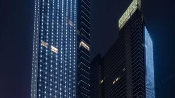 A night view of a cityscape with illuminated skyscrapers.