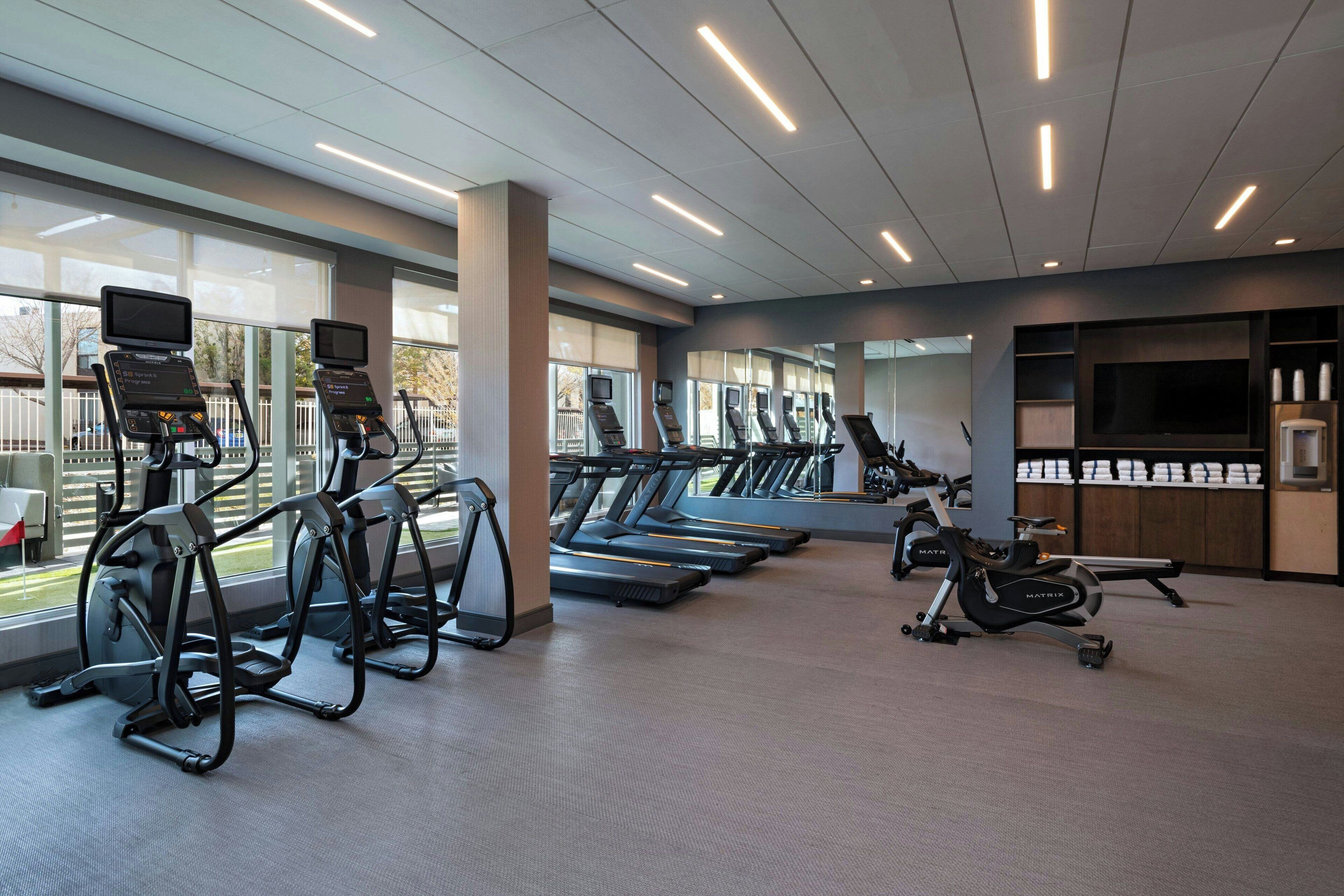 A gym with treadmills, elliptical machines, and a stationary bike.