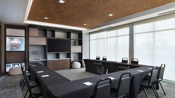 A conference room with a long table, chairs, and a large window.