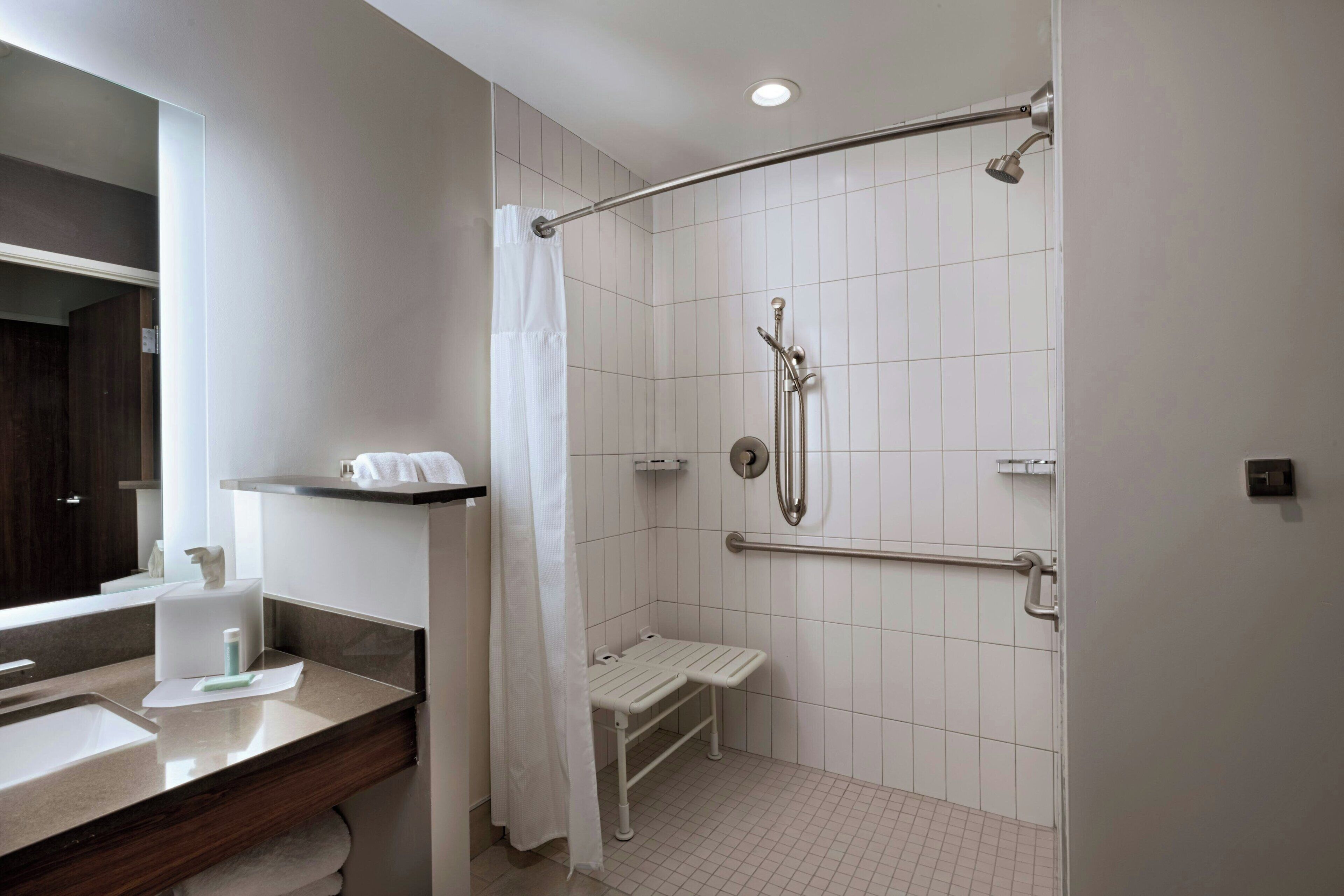 A modern bathroom with a shower, a toilet, and a sink.