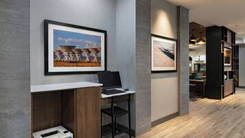 A modern office space with a desk, chair, and framed artwork on the wall.