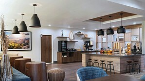 A modern kitchen with a central island, bar stools, and pendant lighting. - Towneplace Suites By Marriott Albuquerque Uptown (Albuquerque)