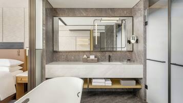 Un baño moderno con un espejo grande, un lavabo blanco y una zona de ducha.
