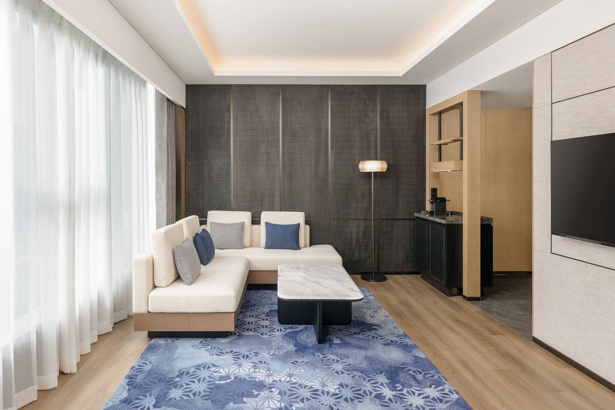 Uma sala de estar moderna com sofá, mesa de centro e televisão.