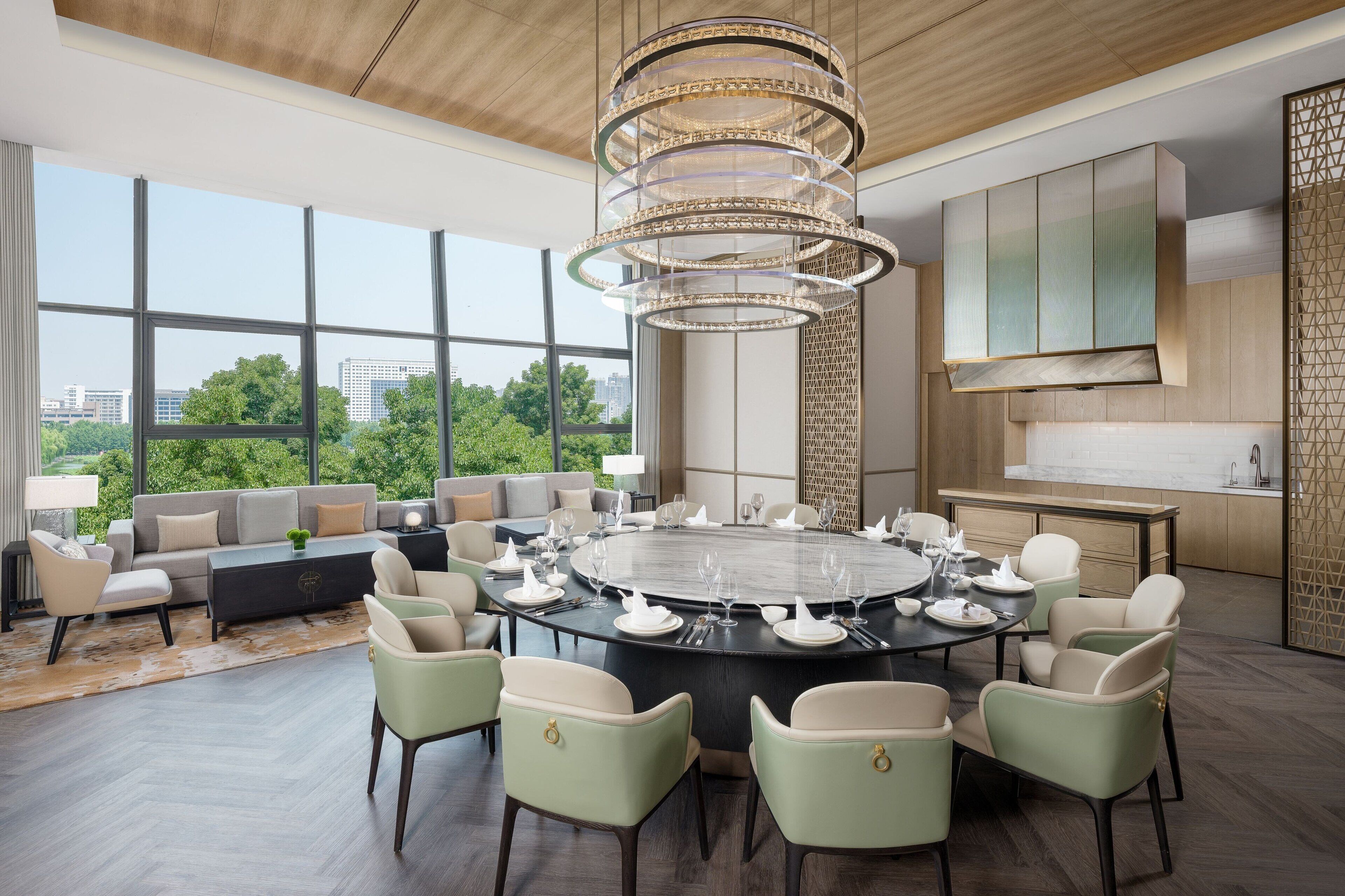 A modern dining area with a round table set for six, surrounded by six chairs.