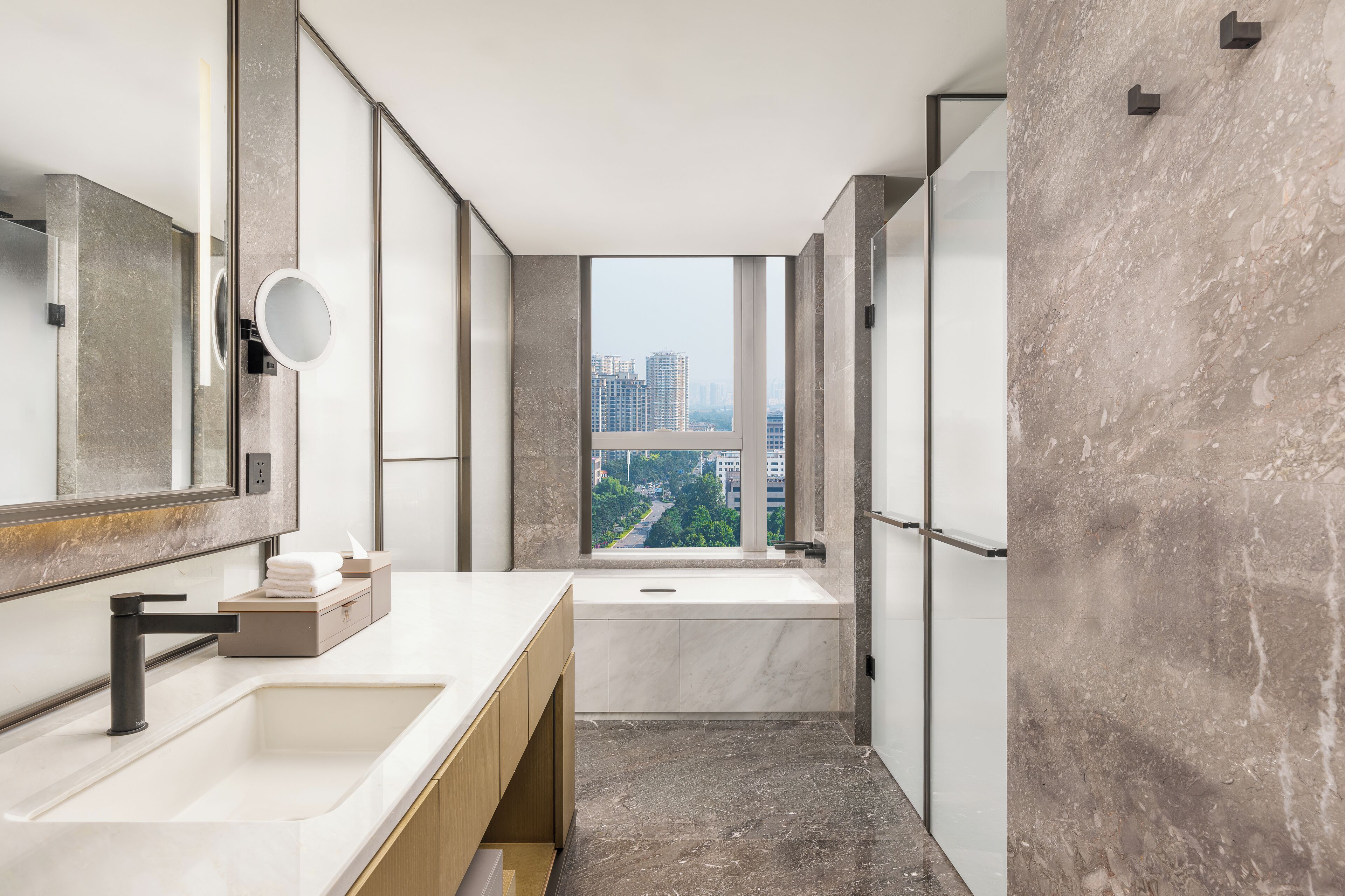 A modern bathroom with a large mirror, a sink, and a bathtub.