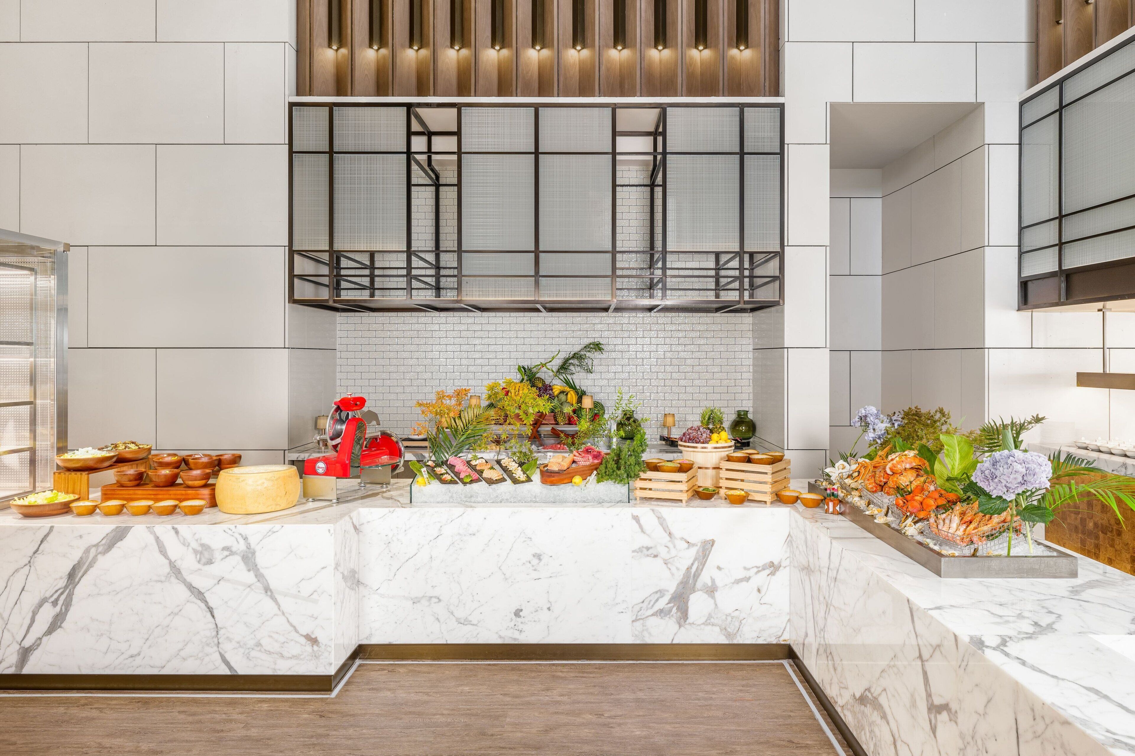 Une cuisine moderne dotée de plans de travail en marbre, d’une cuisinière encastrée et d’une variété d’aliments et d’objets de décoration.