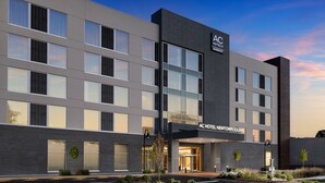 A modern hotel building with a prominent entrance, large windows, and a landscaped driveway. - AC Hotel By Marriott Newtown Square (Newtown Square)