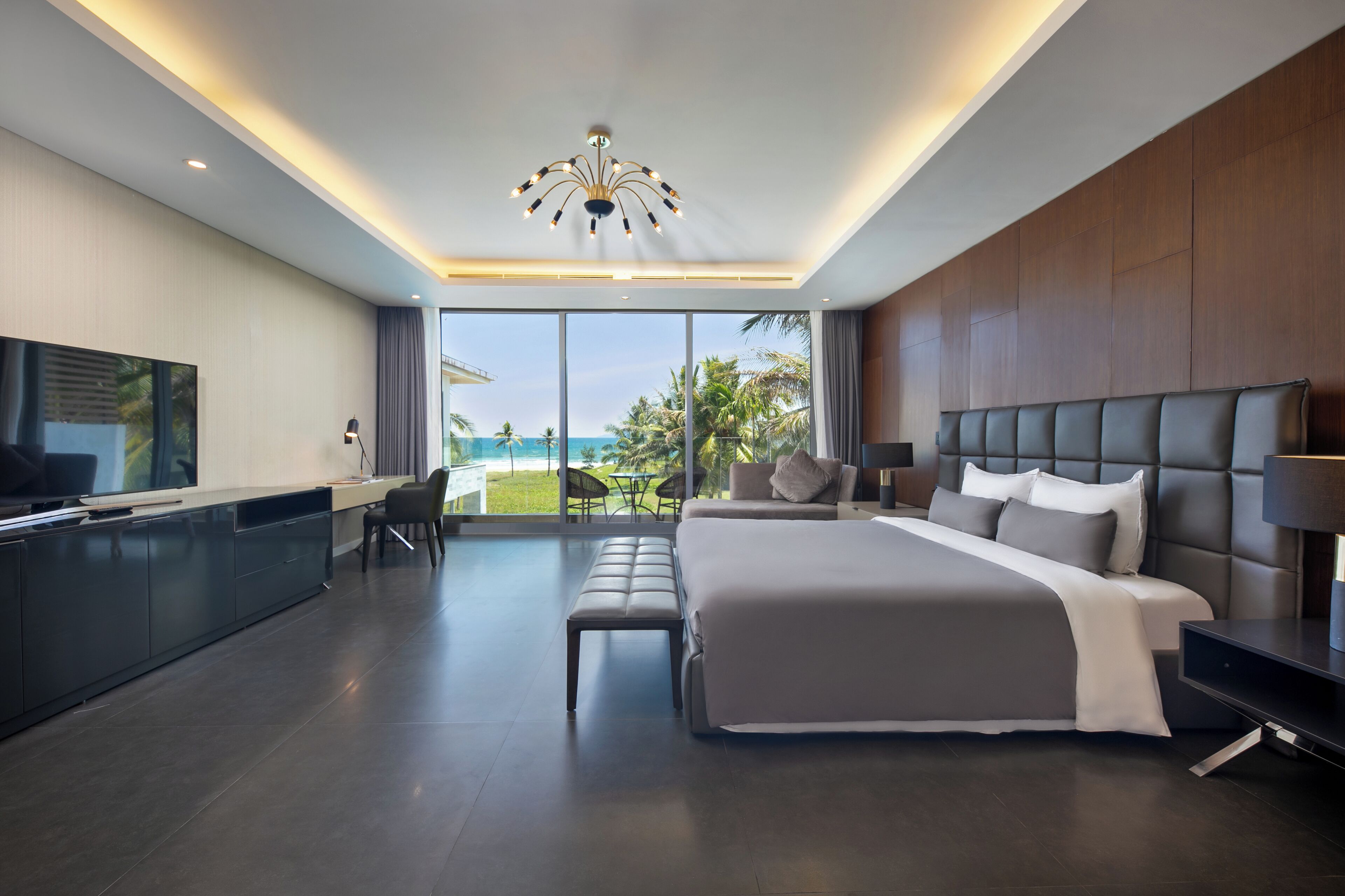 Una habitación de hotel moderna con una cama grande, un escritorio y un televisor.