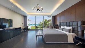A modern hotel room with a large bed, a desk, and a TV. - Abogo Da Nang OceanFront Luxury Villa (Da Nang)