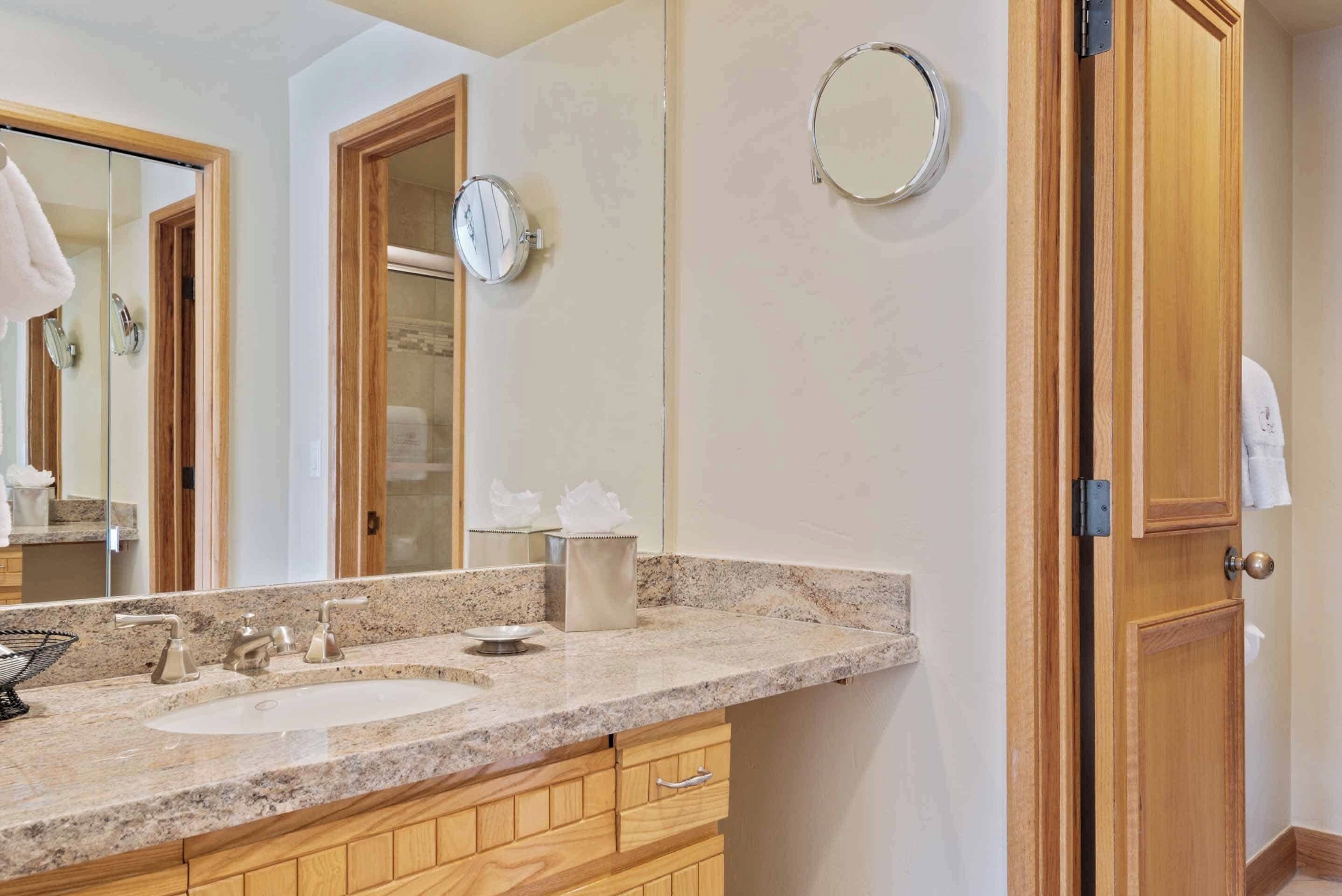 Une salle de bain avec deux lavabos, des meubles en bois, un miroir et un porte-serviettes.