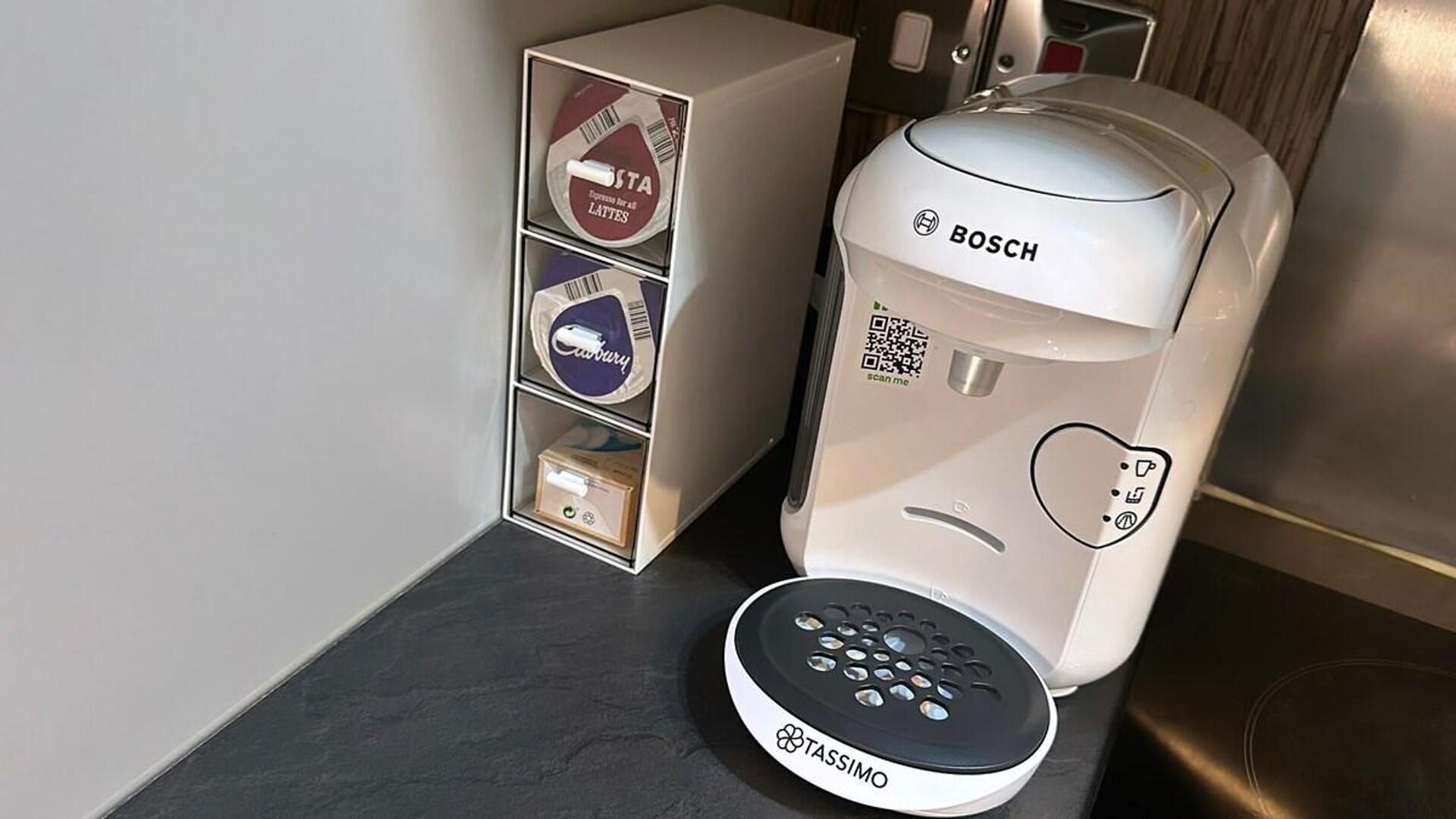 A coffee machine and a coffee pod dispenser in a hotel room.