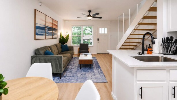 A modern apartment with a kitchen, dining area, and living room.