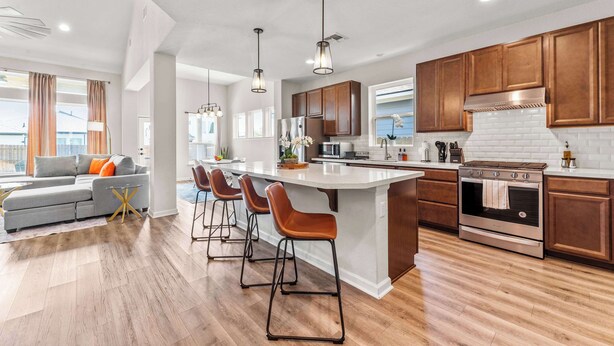 A modern kitchen with a large island, wooden cabinets, and a built-in oven. - Close to CotA & Downtown | Cozy & Luxe | 4BR (Austin)