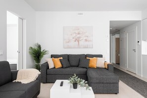 Premium-Apartment, Flussblick | Wohnzimmer | 65-Zoll-Smart-TV mit Kabelempfang, Netflix, Streaming-Dienste