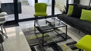 A modern living room with a sofa, a green armchair, and a coffee table. - Urban, Sleeps 6 Private Garden-family Pet Friendly (Croydon)