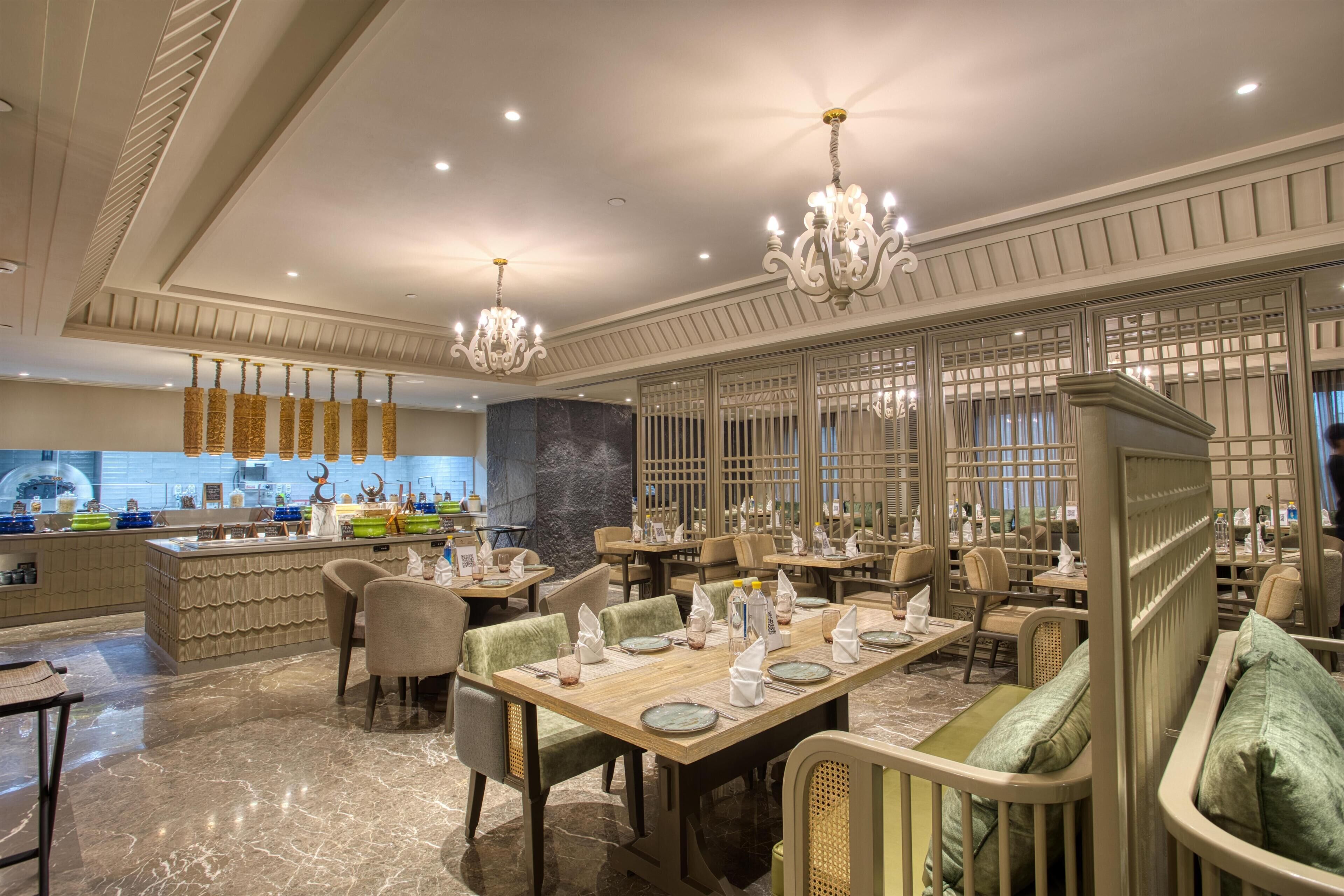 A restaurant with marble flooring, wooden tables, and upholstered chairs.