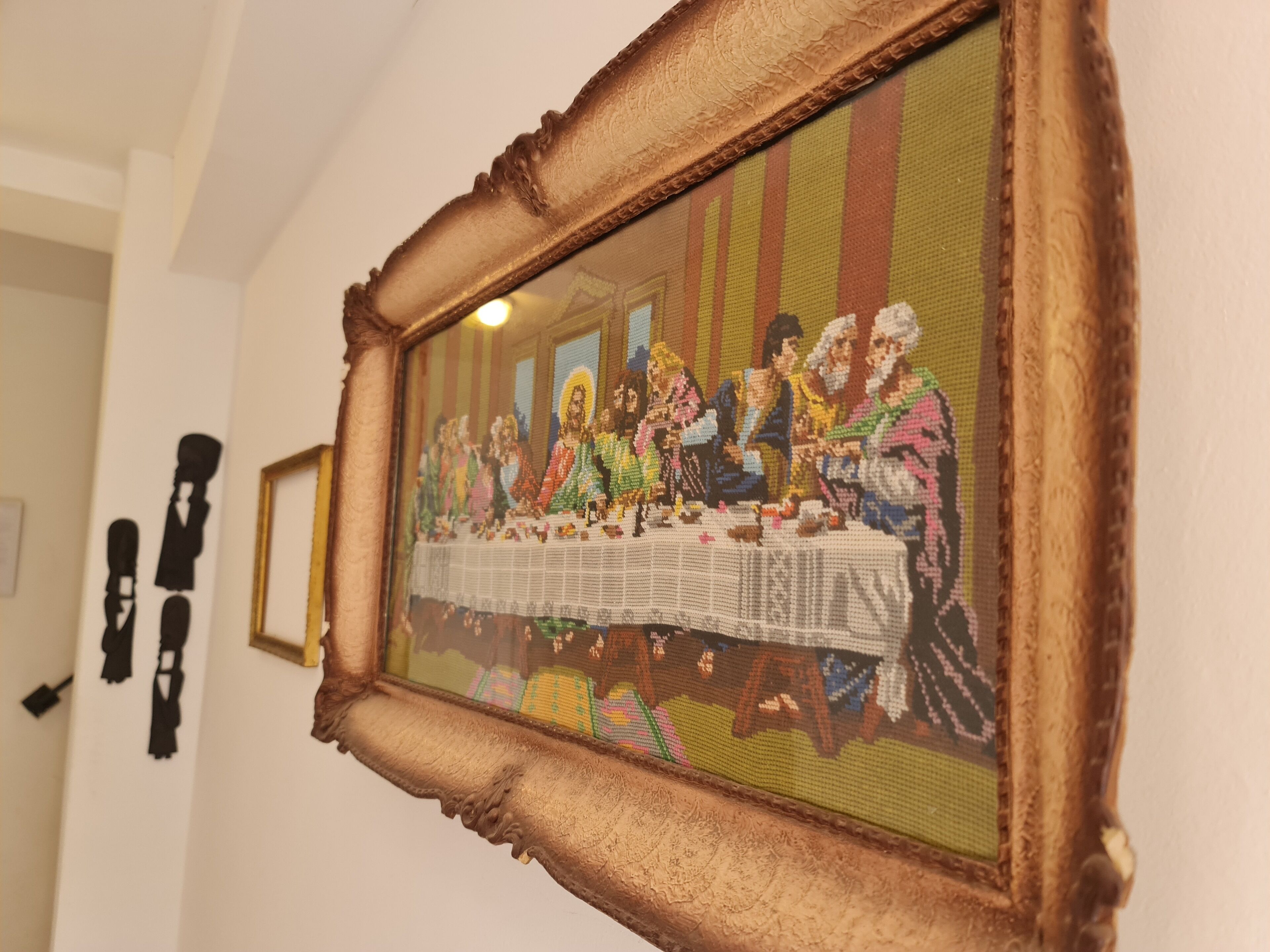 A framed artwork depicting a historical scene with multiple figures seated at a table.