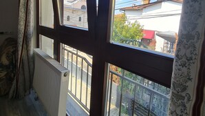 Una stanza con ampie finestre, un termosifone e vista su un edificio con una cupola e una torre.