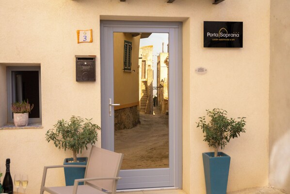A hotel entrance with a door, a sign for 'Porta Soprana', and two potted plants. - PORTA SOPRANA Luxury guest house &Spa (Sclafani Bagni)