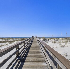 A wooden boardwalk leading to a beach with sand dunes and a clear blue sky. - Big Dreams! Beachfront, relaxing and tranquil vacation! (Gulf Shores)