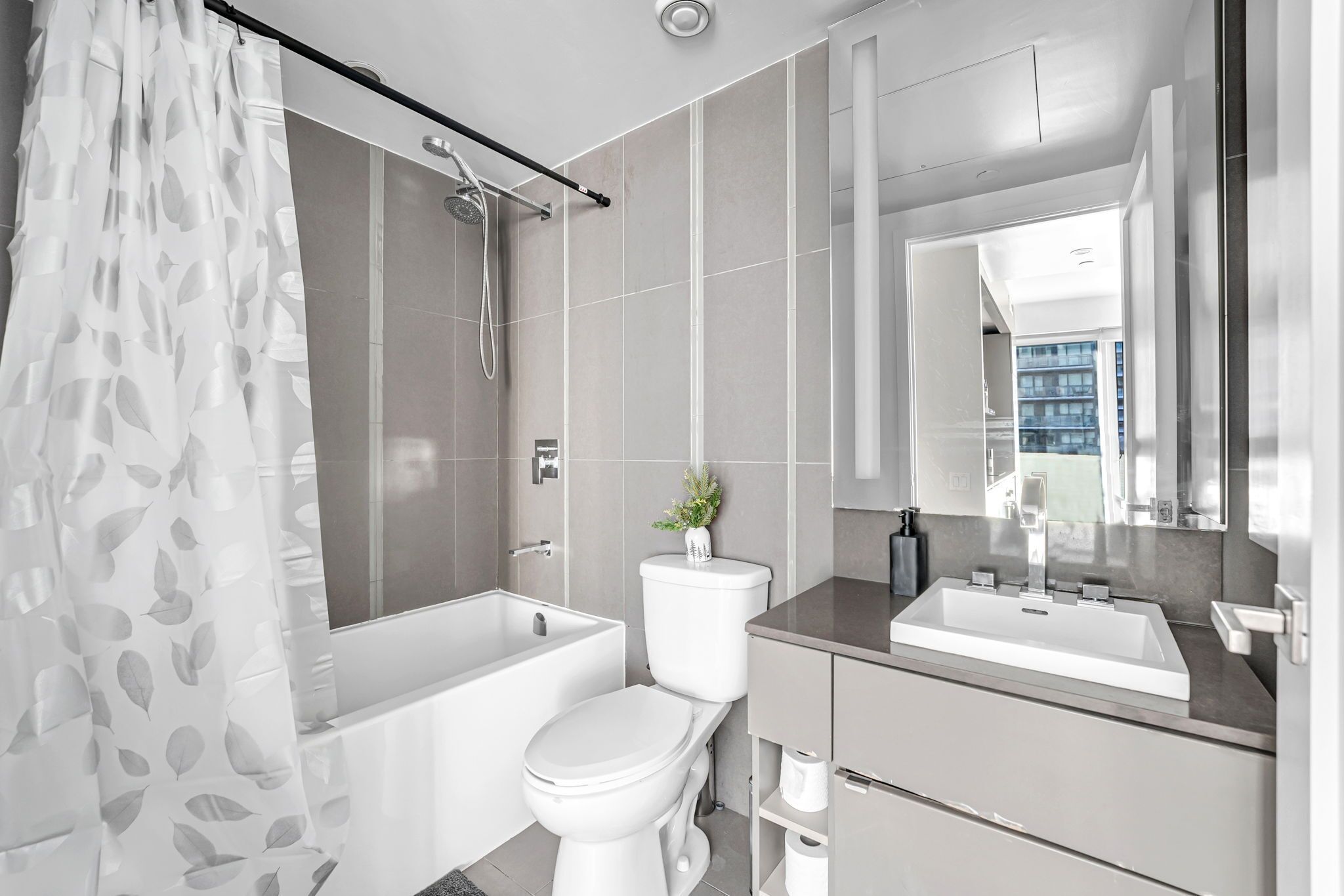 A modern bathroom with a bathtub, toilet, and sink.