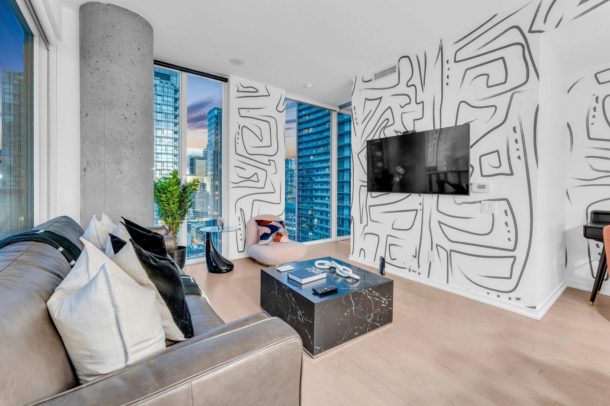 Un salon moderne avec un canapé, une table basse et un téléviseur fixé au mur.