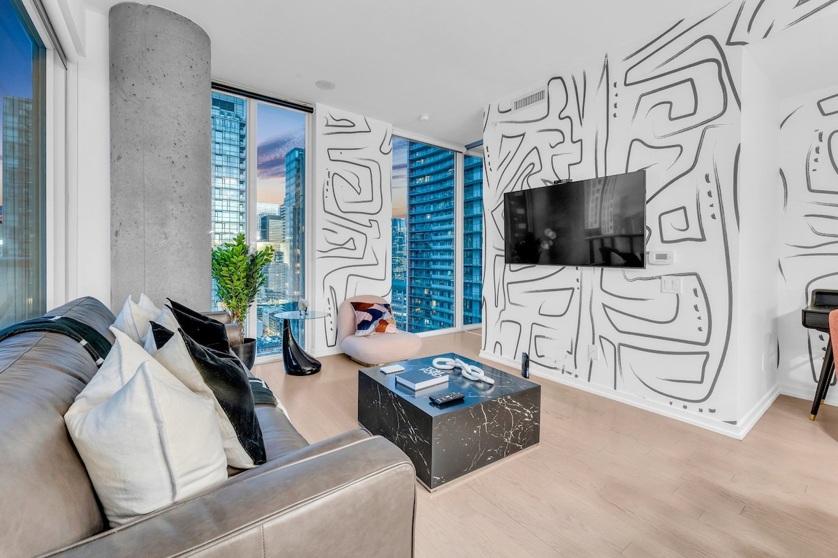 A modern living room with a sofa, coffee table, and a TV mounted on the wall.