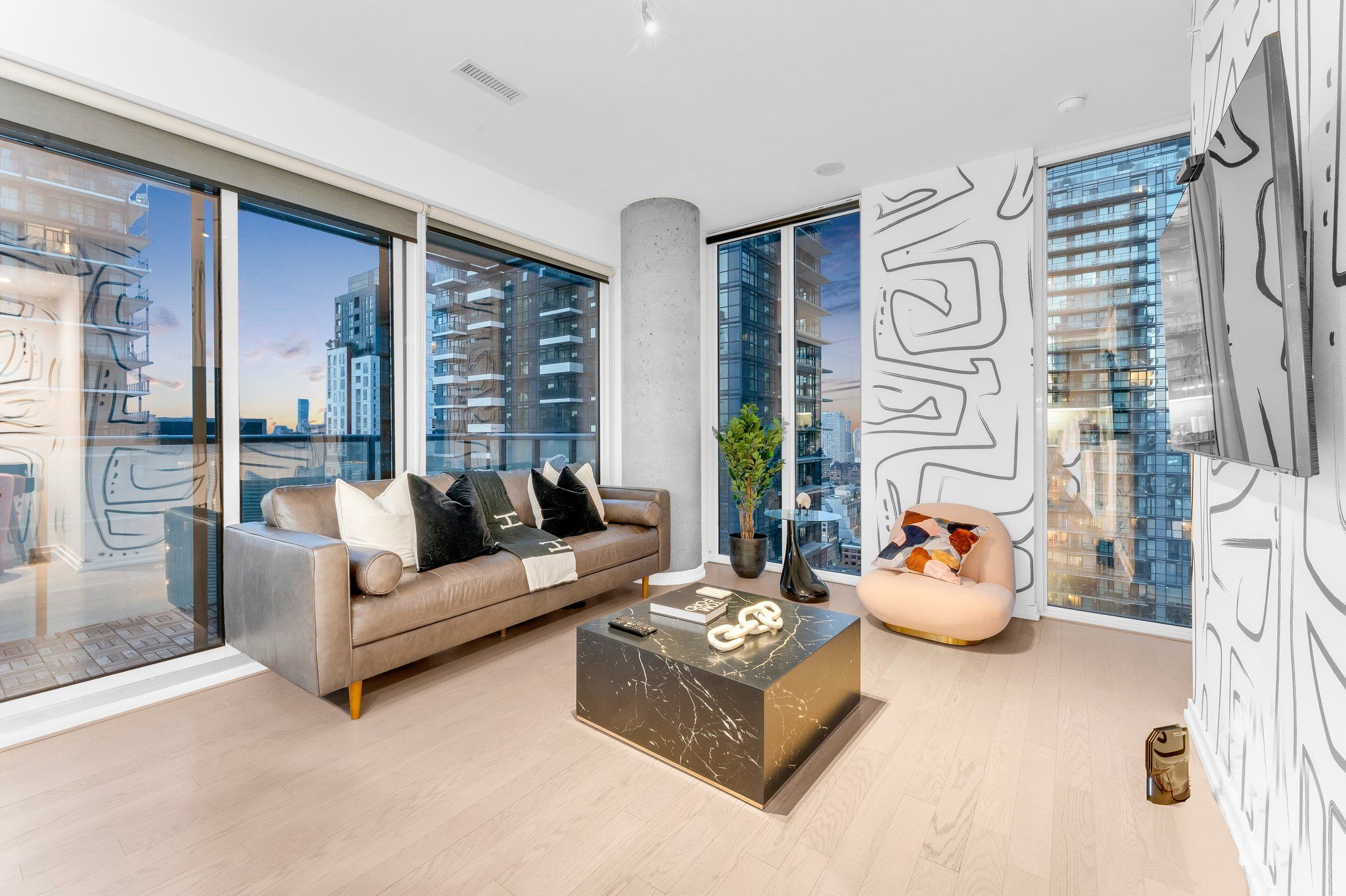 A modern living room with a sofa, a coffee table, and a decorative wall piece.