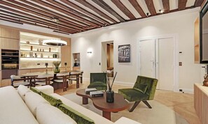 A modern living room with a wooden ceiling, a dining area with a table and chairs, and a green armchair.