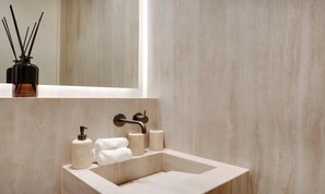 A bathroom with a beige sink, two towel dispensers, and a mirror above the sink. - LUX - PARISIAN RETREAT:EXQUISITE 3-BEDROOM IN SAINT GERMAIN (Paris)