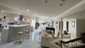 A spacious living area with a kitchen, a dining area, and a bar. - Minutes from I495/200/95, DC and VA. Family sized guest suite with games to play (Silver Spring)
