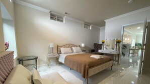 A modern bedroom with a large bed, bedside tables, a seating area, and a bathroom visible through an open door. - Minutes from I495/200/95, DC and VA. Family sized guest suite with games to play (Silver Spring)