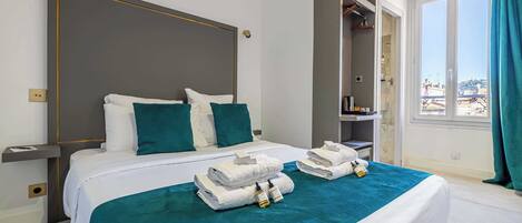 Une chambre d’hôtel avec un grand lit, une armoire, une salle de bain et une vue sur la ville.