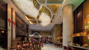 A spacious lobby with traditional wooden furniture, a marble floor, and a modern chandelier. - Floral Hotel · YunFu City King Royal Hotel (Yunfu)